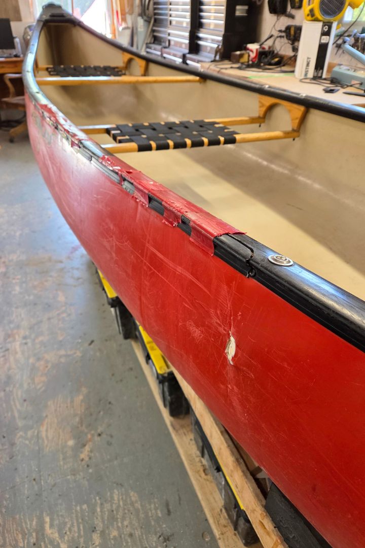Plat-bord brisé sur canot rouge en T-Formex dans l'atelier Canots Légaré